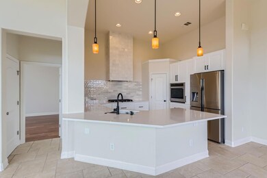 Kitchen featuring decorative backsplash, light co
