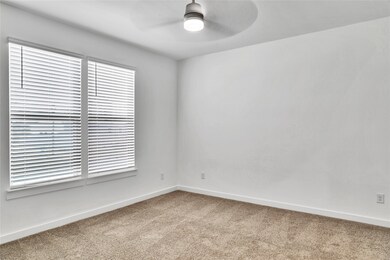 Empty room with carpet, a ceiling fan, and baseboards