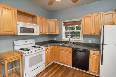 Kitchen with white appliances, dark countertops, b