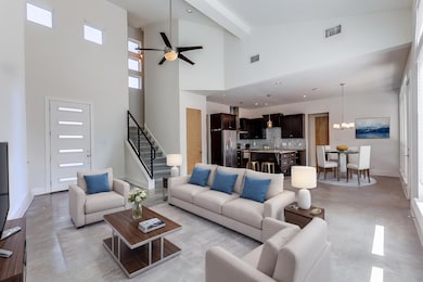 Living area featuring visible vents, stairway, ce
