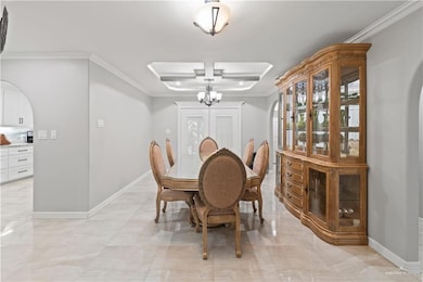 Dining space with arched walkways, ornamental molding, a chandelier, and plenty of natural light