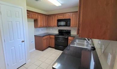 Kitchen with black appliances, brown cabinets, li
