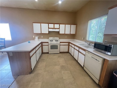 Kitchen featuring white appliances, a sink, under