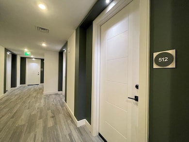 Hall with light wood-type flooring and recessed lighting