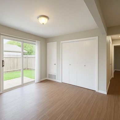 Unfurnished bedroom with access to outside, wood 