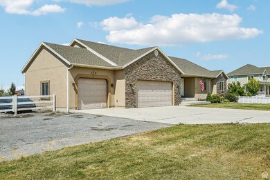 Single story home featuring an attached garage, concrete driveway, stucco siding, stone siding, and a shingled roof