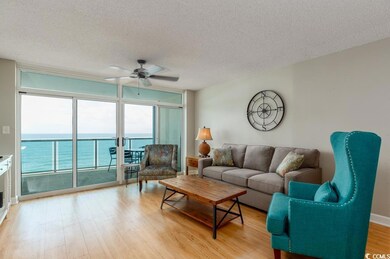 Living area with a wall of windows, ceiling fan, a