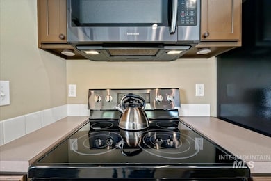 Kitchen view of electric range oven and stainless steel microwave