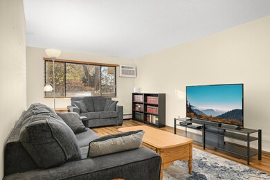 The spacious Living Room. You will love the clean laminate wood flooring throughout the entire space. New A/C unit in 2024.