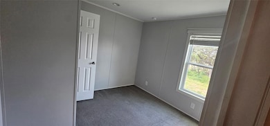 Carpeted empty room featuring ornamental molding 