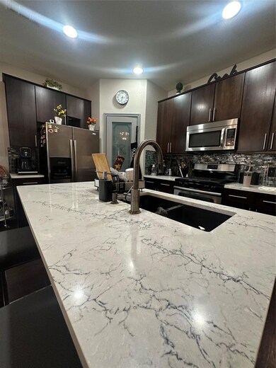 Kitchen with stove, refrigerator, tasteful backsp