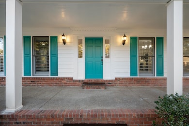 Doorway to property with a porch and brick siding