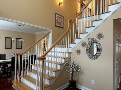 Stairs with visible vents, crown molding, and a hi