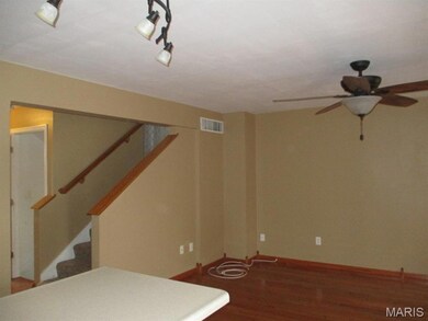 Finished basement with dark wood-type flooring, stairs, and ceiling fan