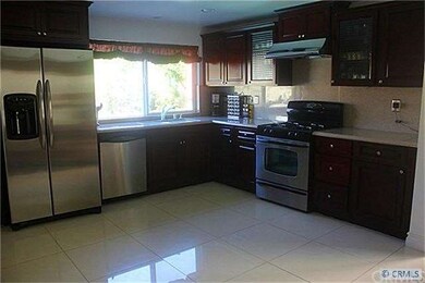 Newly upgraded kitchen with custom mahogany cabinets,granite counter tops, recessed lighting  and decorative glass.