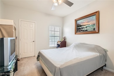 Bedroom with light colored carpet and a ceiling fan