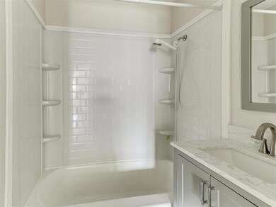 Bathroom featuring tiled shower / bath and vanity with extensive cabinet space