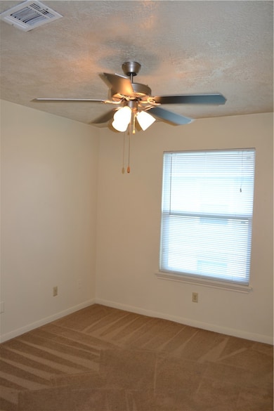 Spare room featuring visible vents, a textured cei