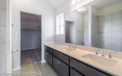 Bathroom with tile patterned floors, double vanit