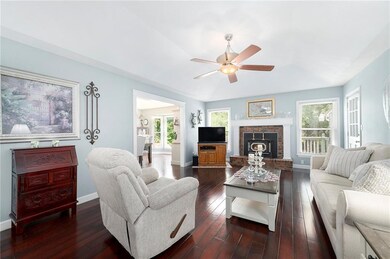 Living room featuring a ceiling fan, dark wood finished floors, and a fireplace