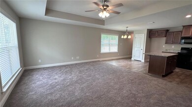 Kitchen with black appliances, dark carpet, and ba