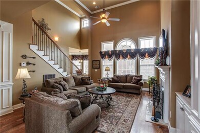 Great room makes a statement with wonderful windows, high ceiling, Fireplace with logs, built ins,  hardwood flooring and heavy trim.