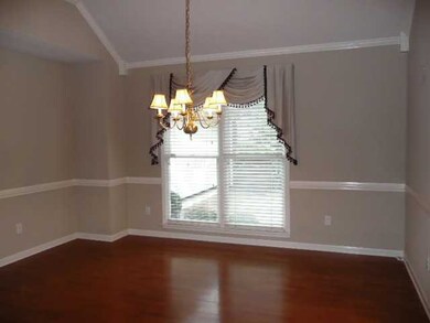 Dining room has rich hardwood flooring, a recessed