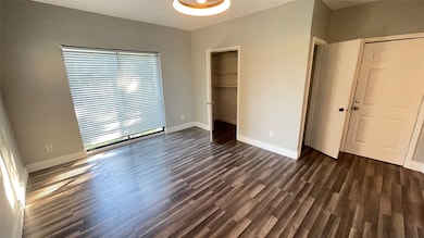 Light-filled living/sleeping area featuring ceiling fan, closets, Juliette balcony and updated vinyl plank flooring.
