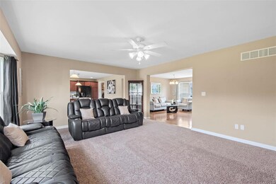 Another view of the living room with neutral carpe