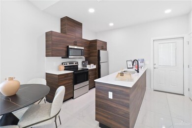 Kitchen featuring modern cabinets, marble finish floor, a sink, appliances with stainless steel finishes, and light countertops
