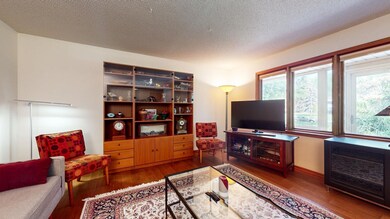 Large living room featuring wood floors and front facing windows.