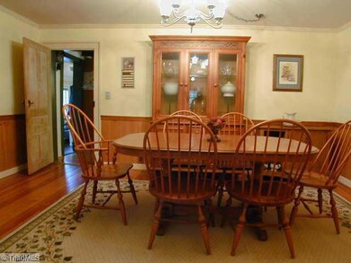 Dining Room. Large formal dining room showing door to kitchen, pine floors, chair rail and wainscotting.