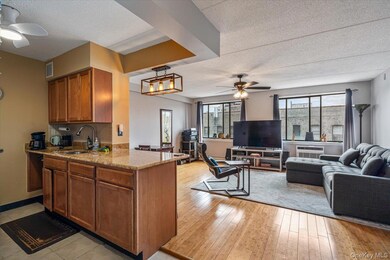Kitchen featuring a sink, a ceiling fan, a textured ceiling, brown cabinetry, and open floor plan