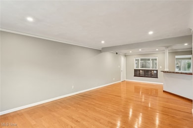 Unfurnished living room featuring crown molding, recessed lighting, and light wood-style flooring