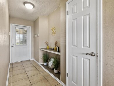 Foyer entrance featuring light tile floors and a t