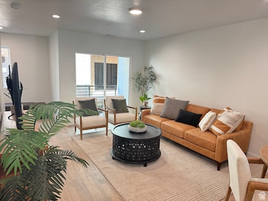 Living room with light wood-type flooring and recessed lighting