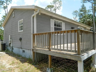 Rear view of house with a wooden deck and crawl sp