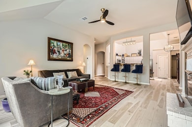 Living room with arched walkways, ceiling fan, li