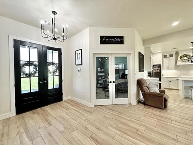 Foyer featuring a notable chandelier, french doors