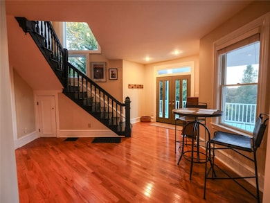 Breath taking entry with SO much going on.  Real hardwood floors illuminated by natural light flooding in courtesy of large windows, glass front door & a transom window, WOW!