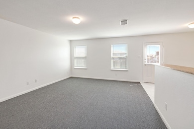 Empty room featuring light colored carpet and baseboards
