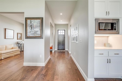 Hallway with wood finished floors, baseboards, and