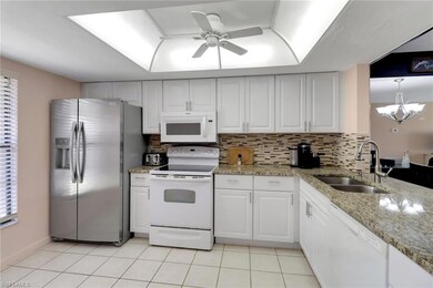 Kitchen featuring backsplash, ceiling fan, a sink,