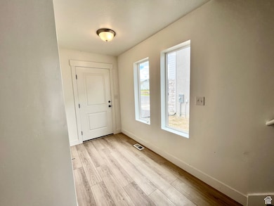 Foyer with baseboards and light wood finished floors