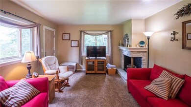 Neutral colors and a corner stone fireplace create