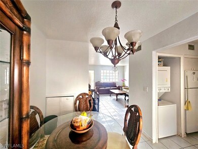 Tiled dining room featuring stacked washer / dryer