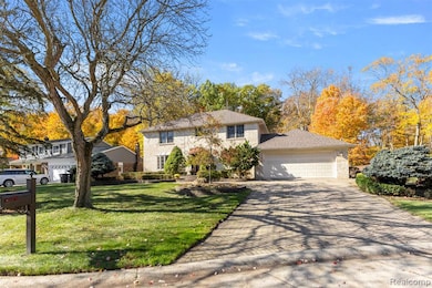 View of front of house with an attached garage, driveway, and a front yard
