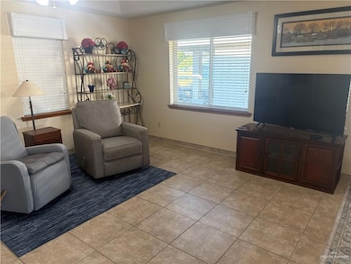 Living area featuring light tile patterned floors and a textured ceiling
