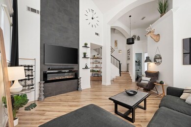 Living room with a large fireplace, stairway, wood
