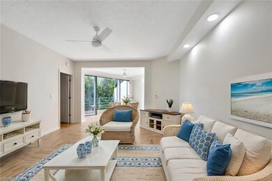 Living room with ceiling fan and light parquet flo